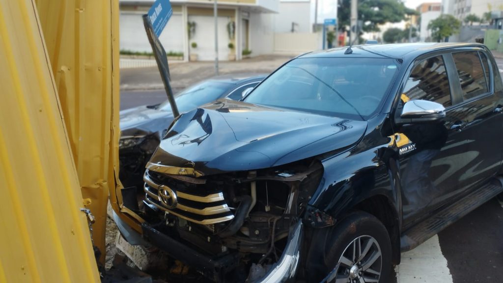 Hilux e Civic batem no Centro de Cascavel e atingem tapume metálico após impacto Imagem referente a Hilux e Civic batem no Centro de Cascavel e atingem tapume metálico após impacto