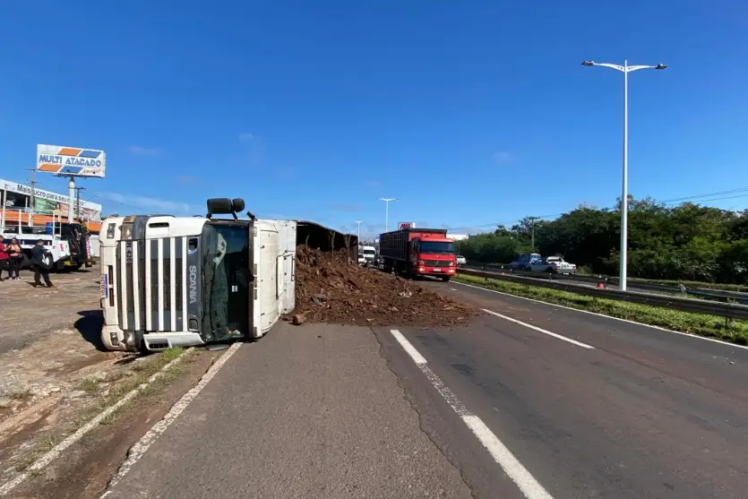 Carreta carregada com serragem tomba na PR-323 em Umuarama e trânsito fica lento Imagem referente a Carreta carregada com serragem tomba na PR-323 em Umuarama e trânsito fica lento